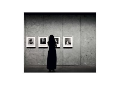 Photographie prise dans le sous sol du Luma à Arles. Une personne regarde attentivement les photos exposées